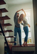 © Sanc/peopleimages.com - Love, couple and dancing in home, bonding and having fun together for romance. Dance, happy and man and woman, funny and care, affection and enjoying quality time by stairs to relax on anniversary.