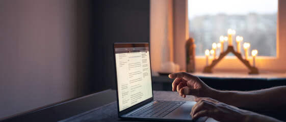 Elderly woman with a laptop. An old woman works at home on a laptop.