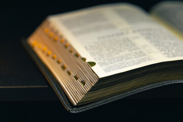 Open Bible on a black background. Religion concept.