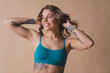 © deagreez - Photo of gorgeous young lady touch hair look empty space wear cyan lingerie isolated beige background no retouch