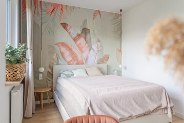 modern bedroom with textured wallpaper with pattern of leaves. design interior of room with pillow a
