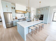 © Kien - kitchen with light blue cabinets, white island and wood floors, neutral color scheme, modern farmhouse style