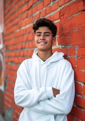 Poster - Portrait of teenage boy leaning on brick wall smiling.