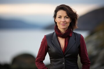 Wall Mural - Portrait of a glad woman in her 40s dressed in a polished vest in calm bay background