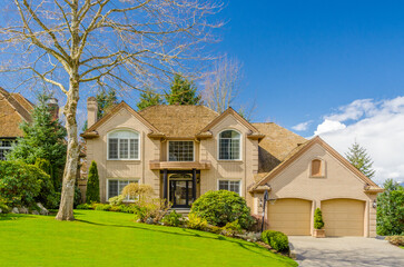 Two story stucco luxury house with nice spring blossom landscape in Vancouver, Canada