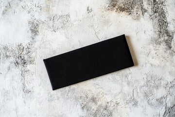 Aufkleber - A piece of black paper sits on a table, ready for use or decoration