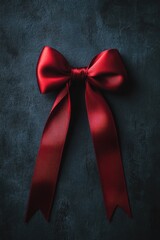Poster - A red bow against a dark background, ideal for use in presentations or designs where a pop of color is needed