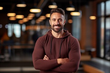 Wall Mural - Portrait of a grinning man in his 30s wearing a cozy sweater on dynamic fitness gym background