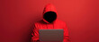 © Wonderful Studio - A figure in a red hoodie sits before a laptop, shrouded in darkness against a bright red background, evoking themes of anonymity and mystery.