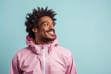 Canvas Print - Portrait of a blissful afro-american man in his 30s wearing a functional windbreaker over pastel or soft colors background