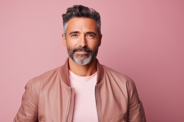 Canvas Print - Portrait of a glad man in his 40s wearing a trendy bomber jacket isolated on pastel or soft colors background