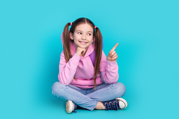 full body photo of cute little girl sit floor point look empty space dressed stylish pink clothes is