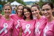 © musfikur - Group of Women Supporting Breast Cancer Awareness in Pink T-Shirts Smiling Together at an Outdoor Event