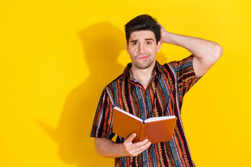 Canvas Print - Photo of nice young man scratch head hold book wear shirt isolated on yellow color background