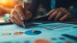 © NfL - A person analyzing business charts and data with a pen in a professional setting.
