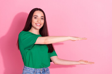 Poster - Photo of shiny attractive lady dressed green t-shirt holding arms empty space isolated pink color background