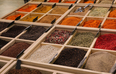 vibrant collection of spices from around the world in colorful containers sold at a busy ethnic market filled