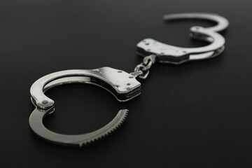 Classic chain handcuffs on black background, closeup