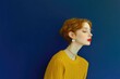 © Konstiantyn Zapylaie - Elegant woman in yellow sweater against deep blue background