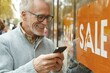 © Konstiantyn Zapylaie - Senior man enjoying shopping season with his smartphone outdoors