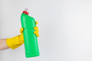 Canvas Print - Woman holding toilet cleaner in bottle on light background, closeup. Space for text