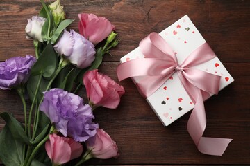 Poster - Gift box with bow and flowers on wooden table, flat lay