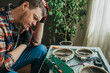 © wifesun - Electrician trying to understand why a modern induction hob is not working, holding a circuit board and thinking about the solution