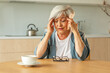© Юлия Завалишина - Headache pain. Unhappy middle aged senior woman suffering from headache sick rubbing temples at home. Mature old senior grandmother touching temples experiencing stress Woman feeling pain hurt in head