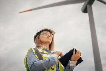 Poster - A skilled woman monitors operations of wind turbines at a stateoftheart renewable energy facility using a tablet, demonstrating her expertise, commitment, and passion for sustainability