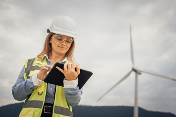 Poster - A skilled female engineer inspects a wind turbine with her tablet, ensuring efficiency and optimal performance, contributing significantly to sustainability and renewable energy initiatives