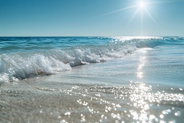 Wall Mural - clear ocean waves rolling towards a sandy beach the water sparkling under the midday sun