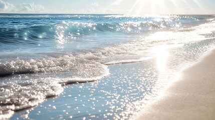Wall Mural - Sunlight sparkling on the surface of the ocean as waves gently roll towards a pristine sandy beach