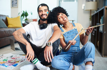 Couple, portrait and painting with smile on floor for bonding, love and romantic activity together. Happy, man and woman with brush by palette at home for creative date, artistic and hobby on weekend