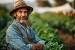 © dyshlivenko - With a warm smile, a seasoned farmer stands confidently among vibrant green vegetable plants, enjoying the sunny afternoon. His rugged attire reflects years of hard work and dedication to his craft.
