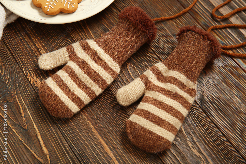 Pair of warm mittens on wooden background