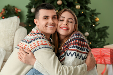 Canvas Print - Young couple hugging in living room decorated for Christmas