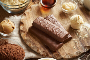 Wall Mural - Protein chocolate bars with ingredients - whey protein powder, peanut butter, raw cacao, honey and maple syrup