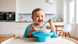 © tanya78 - adorable baby eating porridge in the kitchen