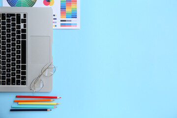 Poster - Workplace of graphic designer with laptop, pencils and color charts on blue background