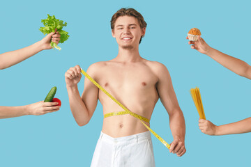 Wall Mural - Young man with tape measure and female hands holding food on blue background. Weight loss concept