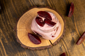 plum yogurt with slices and whole fruits on the table