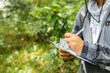 © Carlostock - Biologist writing in a notebook the notes of his research in the middle of the rainforest, in close-up