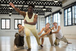 © JackF - Positive afro american man studying movement of contemporary dance in classroom with his friends