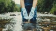 © pattaporn - Hands in Gloved Water at a Serene Stream