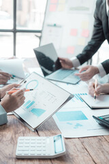 Business people meeting and discussion on charts and graphs showing results of teamwork, close-up of business colleagues analyzing financial data at table in modern office about business strategy