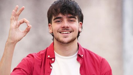 Wall Mural - young man or student smiling outdoors with okay gesture