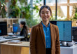 © Azazul - A young woman is standing behind the white office table that has computer monitors on it.