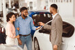 © Prostock-studio - Buying Auto. Salesman Giving Car Key To Buyers For Test Drive Standing In Luxury Dealership Center.