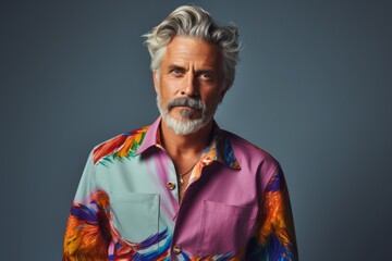 Wall Mural - A man with a beard and gray hair is wearing a colorful shirt with a bird pattern