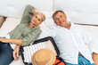 © Sergey - A married couple is ready to travel. A man and a woman with a suitcase are preparing for a summer vacation or travel.